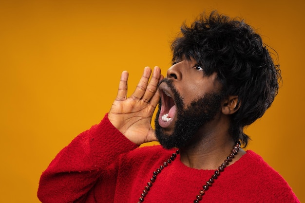 Chico afroamericano gritando contra el fondo amarillo