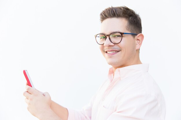 Chico alegre feliz en anteojos con smartphone