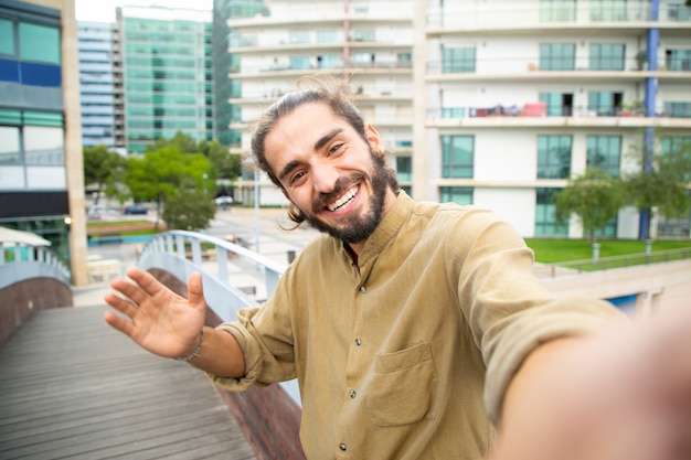 Foto gratuita chico alegre feliz hipster tomando selfie