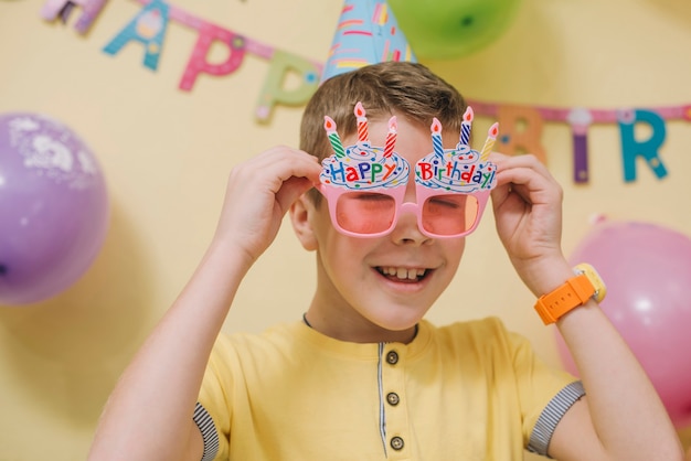 Foto gratuita chico alegre probándose gafas elegantes