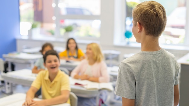 Foto gratuita chico de alto ángulo que presenta en clase