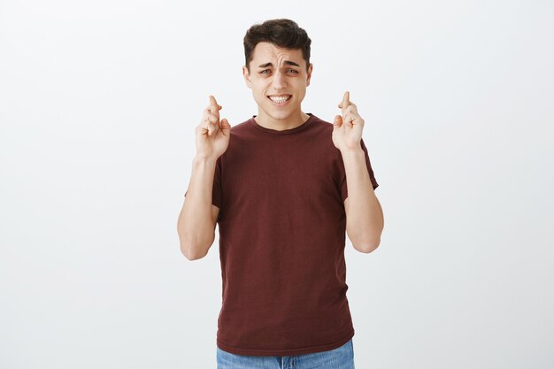 Chico atractivo preocupado ansioso en camiseta roja