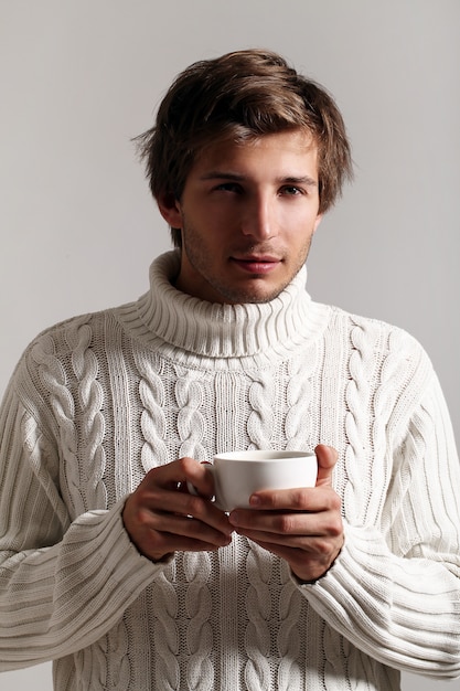 Chico atractivo sosteniendo una taza de café