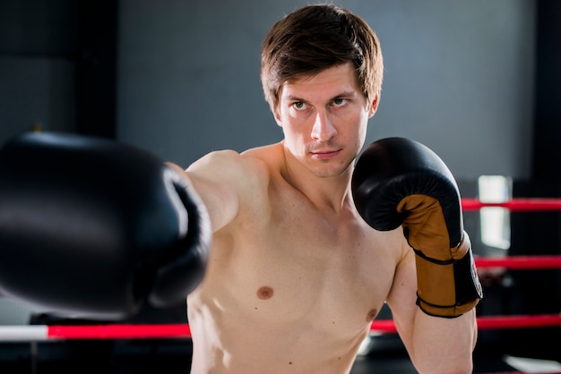 Chico boxeador posando en el gimnasio