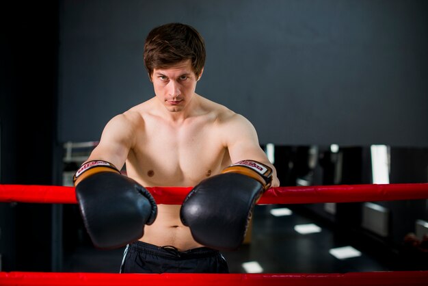 Chico boxeador posando en el gimnasio