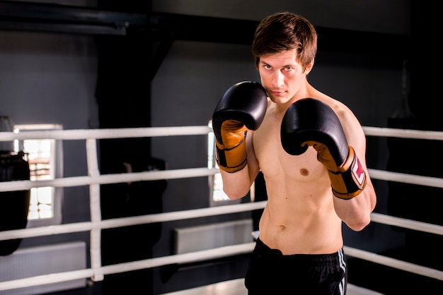 Foto gratuita chico boxeador posando en el gimnasio