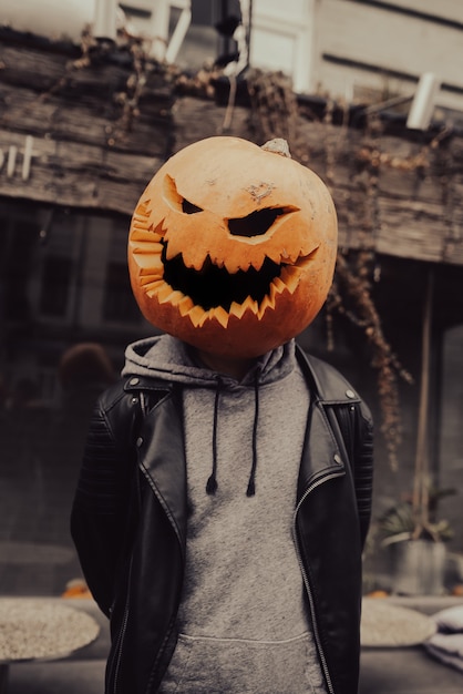 Foto gratuita chico con cabeza de calabaza posa para la cámara