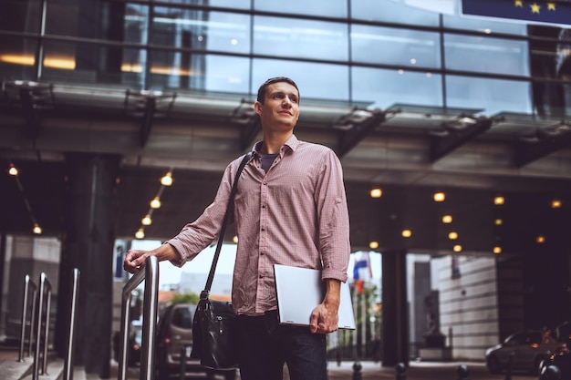 Foto gratuita chico en la calle moderna con ropa informal con laptop