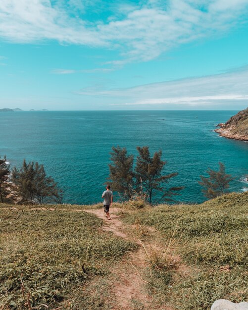 chico caminando por el camino con una hermosa vista del océano