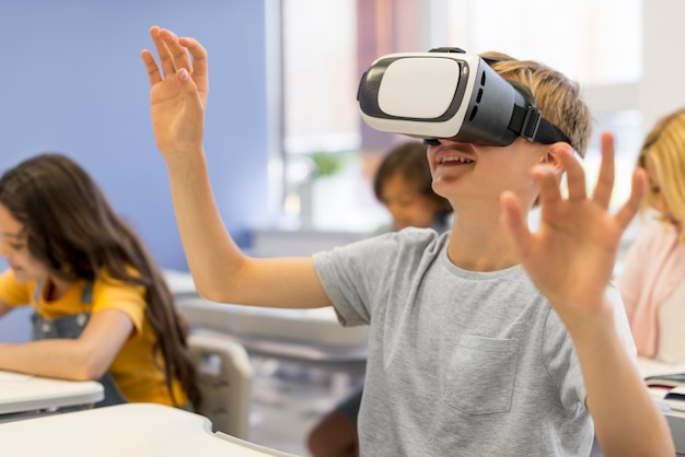 Foto gratuita chico con casco de realidad virtual en la escuela