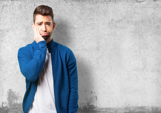 Foto gratuita chico con chaqueta azul con dolor de muelas