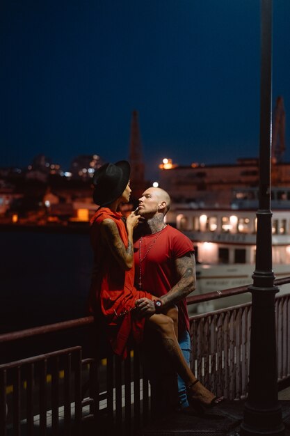 Chico y chica abrazándose en un fondo del puerto nocturno