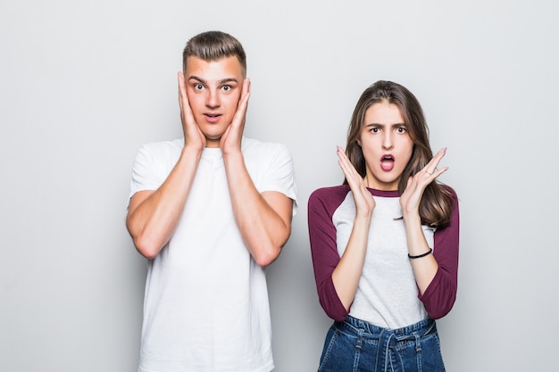 Chico y chica bastante joven guapo pareja tienen noticias inesperadas en blanco