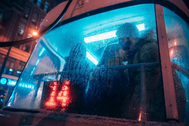El chico y la chica se besan en el tranvía detrás del cristal empañado