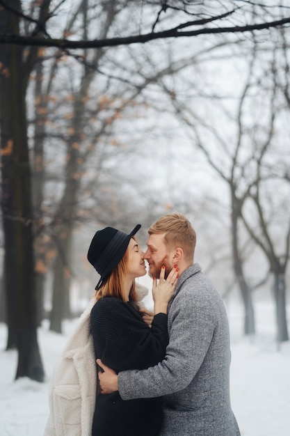 El chico y la chica descansan en el bosque de invierno.