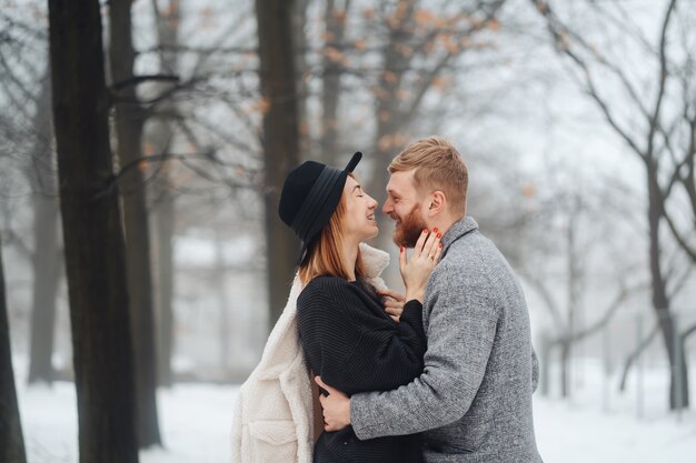 El chico y la chica descansan en el bosque de invierno.