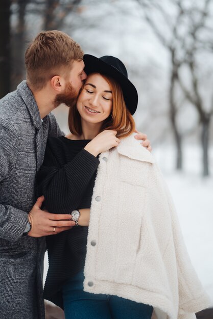 El chico y la chica descansan en el bosque de invierno.