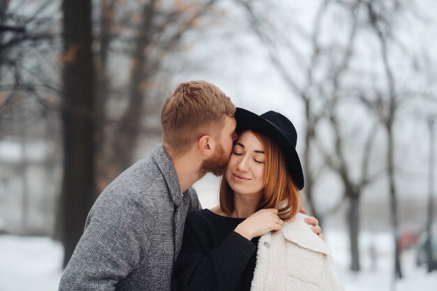 El chico y la chica descansan en el bosque de invierno.