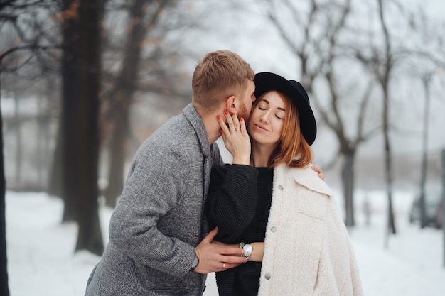 El chico y la chica descansan en el bosque de invierno.