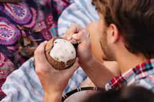 Foto gratuita chico comiendo un coco por la playa