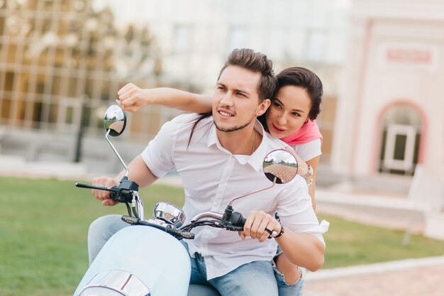 Chico concentrado con barba conduciendo scooter en un cálido día de otoño