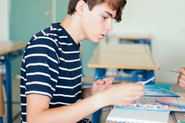 Chico concentrado haciendo sus deberes en clase