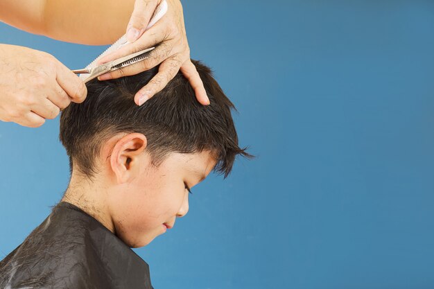 Un chico se corta el pelo por peluquero