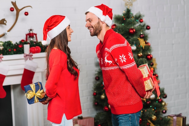 Chico y dama sosteniendo regalos de espaldas