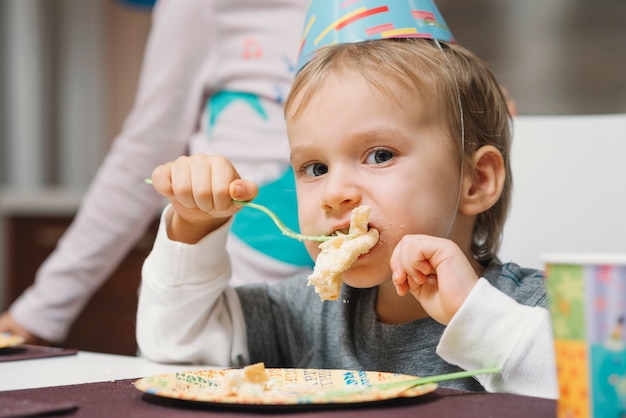 Chico divertido disfrutando de pastel de cumpleaños