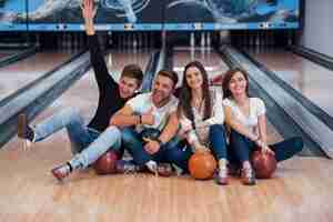 Foto gratuita chico diviértete con los brazos levantados. jóvenes amigos alegres se divierten en el club de bolos en sus fines de semana