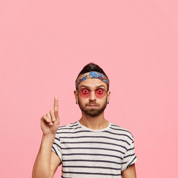 Chico elegante con gafas de sol y diadema colorida