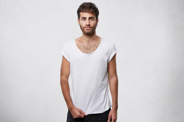 chico elegante mostrando su camiseta blanca vacía en blanco