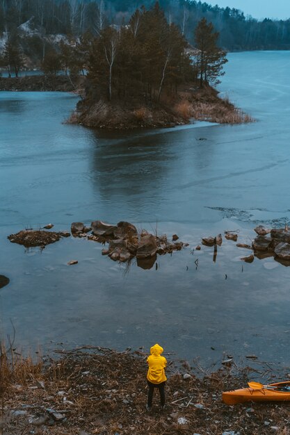 El chico está parado en el lago congelado.