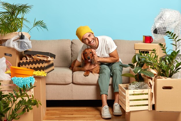 Chico feliz abraza a su perro favorito rodeado de cajas