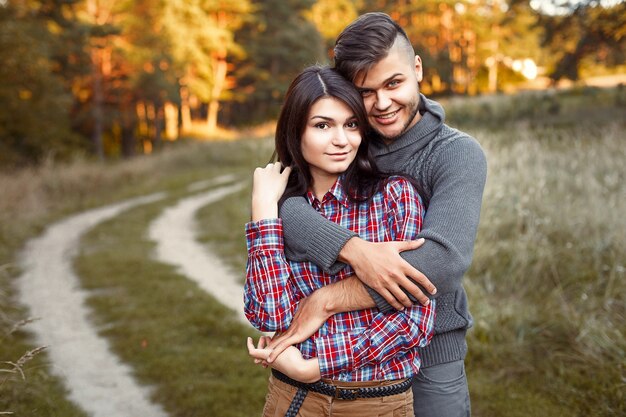 Chico feliz abrazando a su novia en un día de otoño