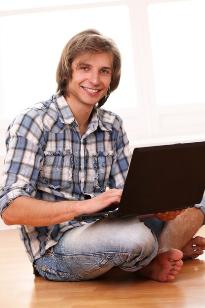 Chico feliz y guapo con laptop