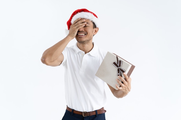 Chico feliz tratando de adivinar lo que hay dentro de la caja de regalo de Navidad