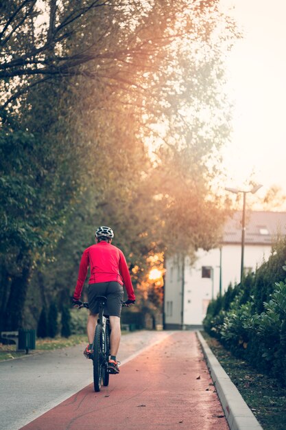 Chico fitness con bicicleta en la carretera