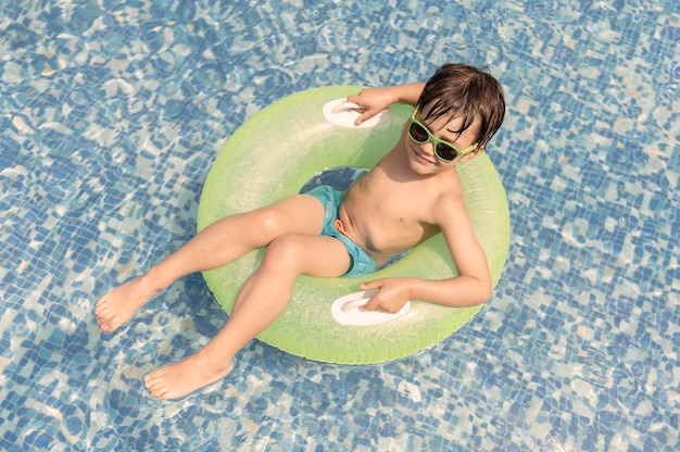 Foto gratuita chico en flotador en la piscina