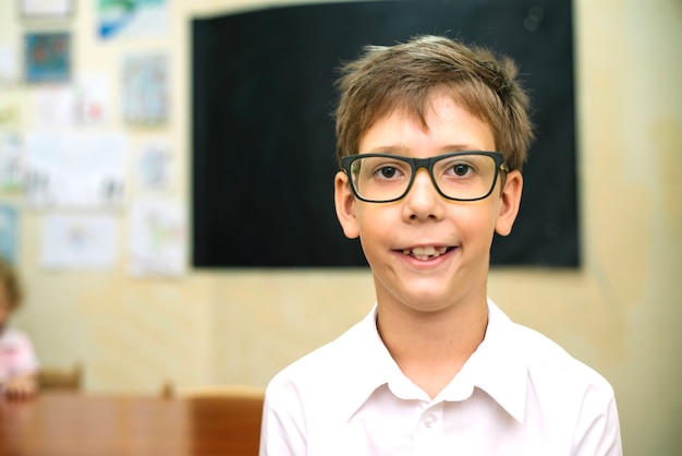 Foto gratuita chico en gafas posando en el aula