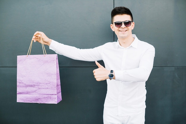 Chico con gafas de sol con bolsa de compras