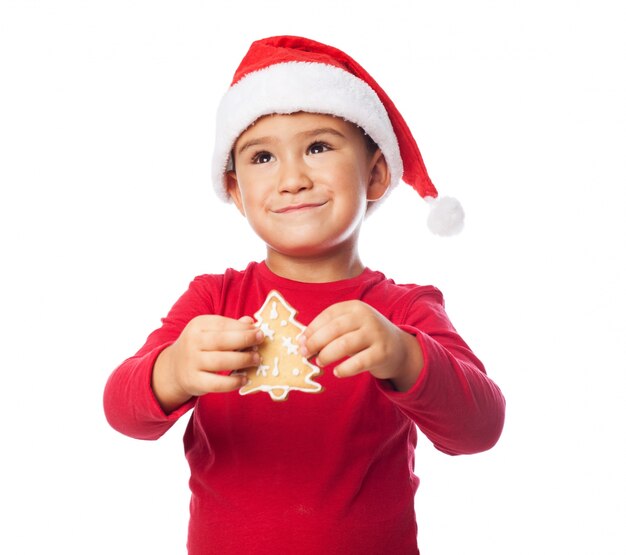 Chico con una galleta de árbol