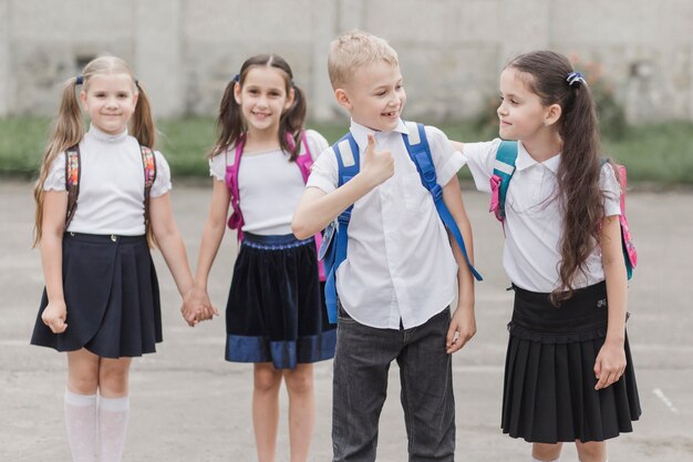 Chico gesticular pulgar arriba mientras está de pie cerca de la niña