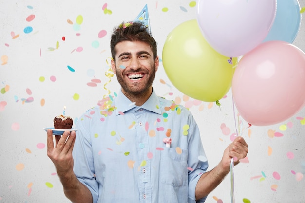 Foto gratuita chico con gorro de fiesta y confeti