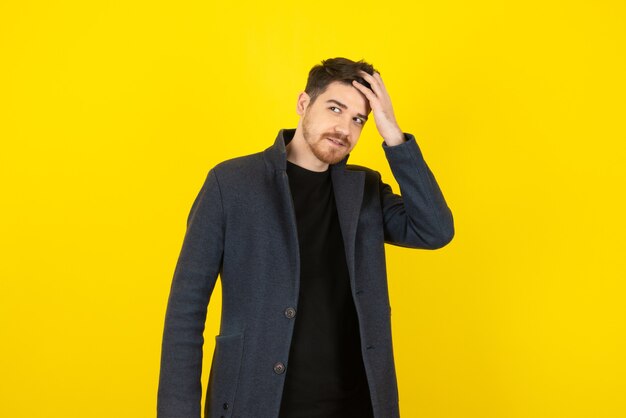 El chico guapo dando forma a su cabello con las manos.