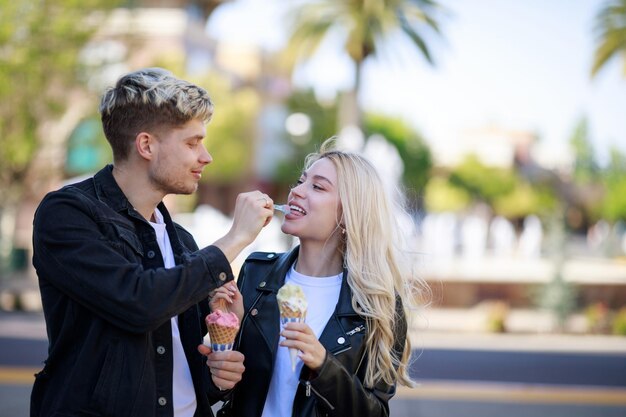 Un chico guapo dando helado a la joven Foto de alta calidad.