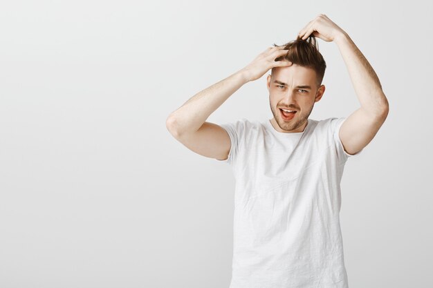 Chico guapo descarado saliendo, haciendo su propio corte de pelo