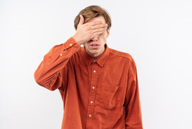 Chico guapo joven con camisa roja cubrió los ojos con la mano