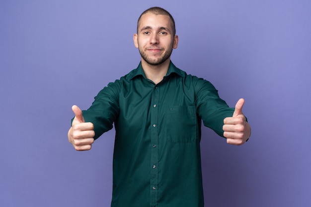 Chico guapo joven complacido con camisa verde mostrando el pulgar hacia arriba