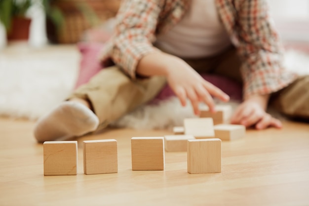 Foto gratuita chico guapo jugando con cubos de madera en casa